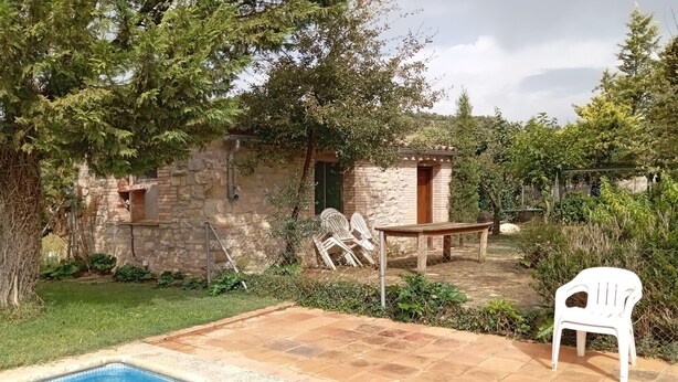 A stone building with a pool, outdoor furniture, and greenery. - Detached rural 19th century country house. (Calonge de Segarra)