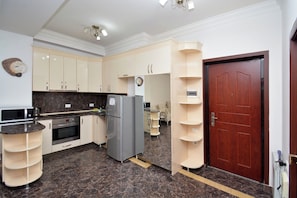 Departamento clásico, 1 habitación, balcón, vista al jardín | Cocina privada | Parrilla de estufa, tetera eléctrica y utensilios de cocina