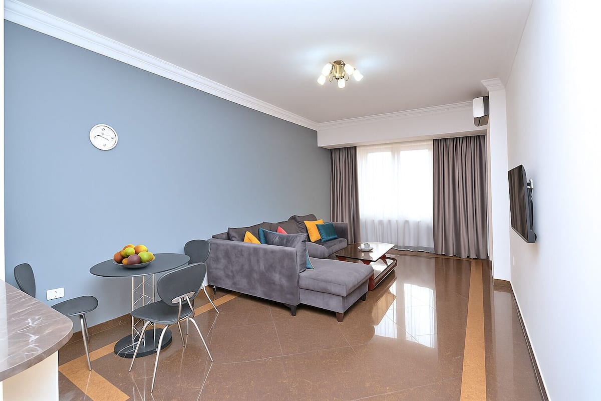 Departamento Confort, balcón, vista al jardín | Área de sala de estar | Televisión de pantalla plana de 50 pulgadas con canales por cable