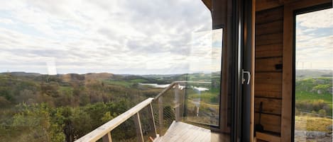 A modern interior with a large glass door leading to a scenic outdoor view.