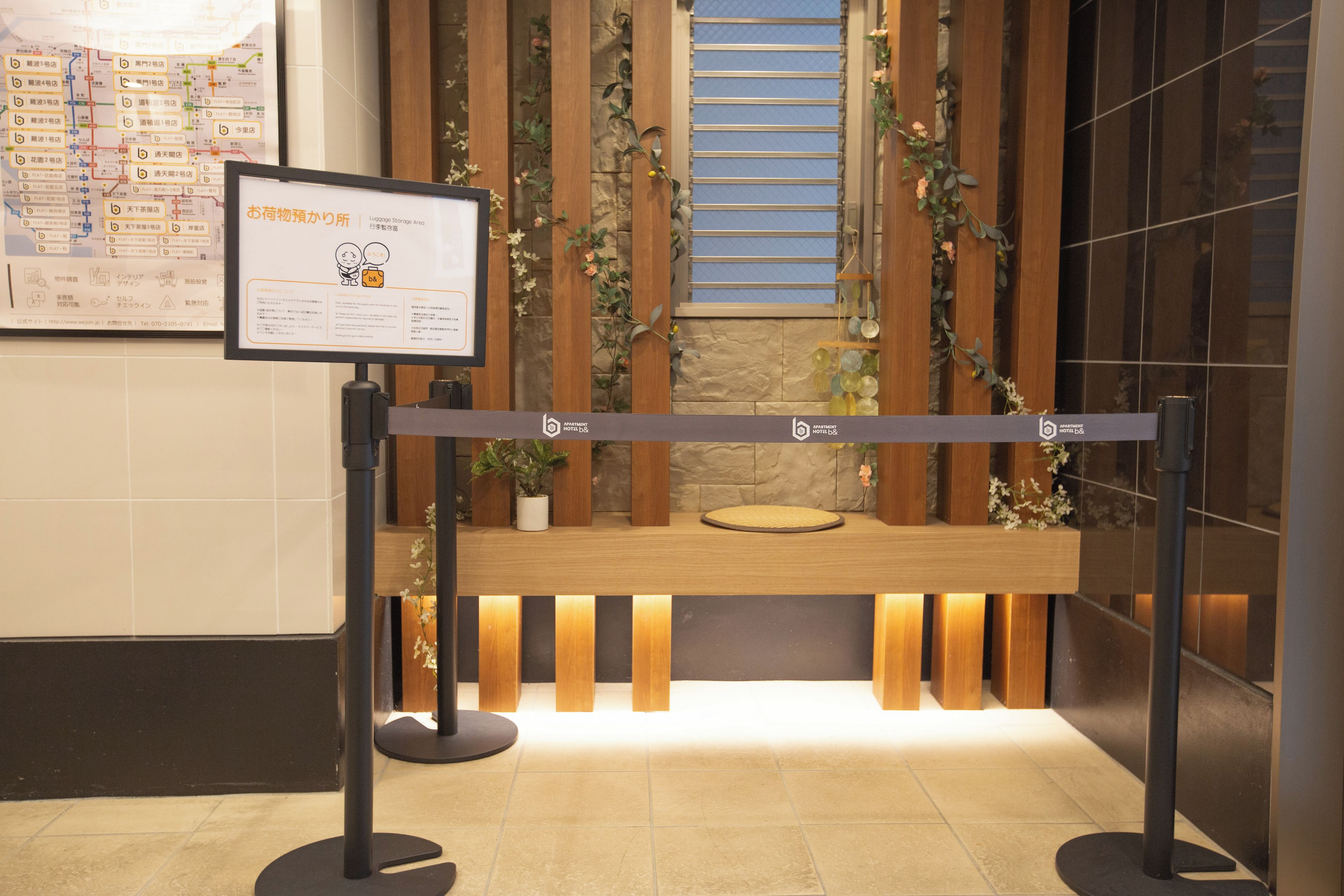 A reception desk with a sign, wooden paneling, and a potted plant.