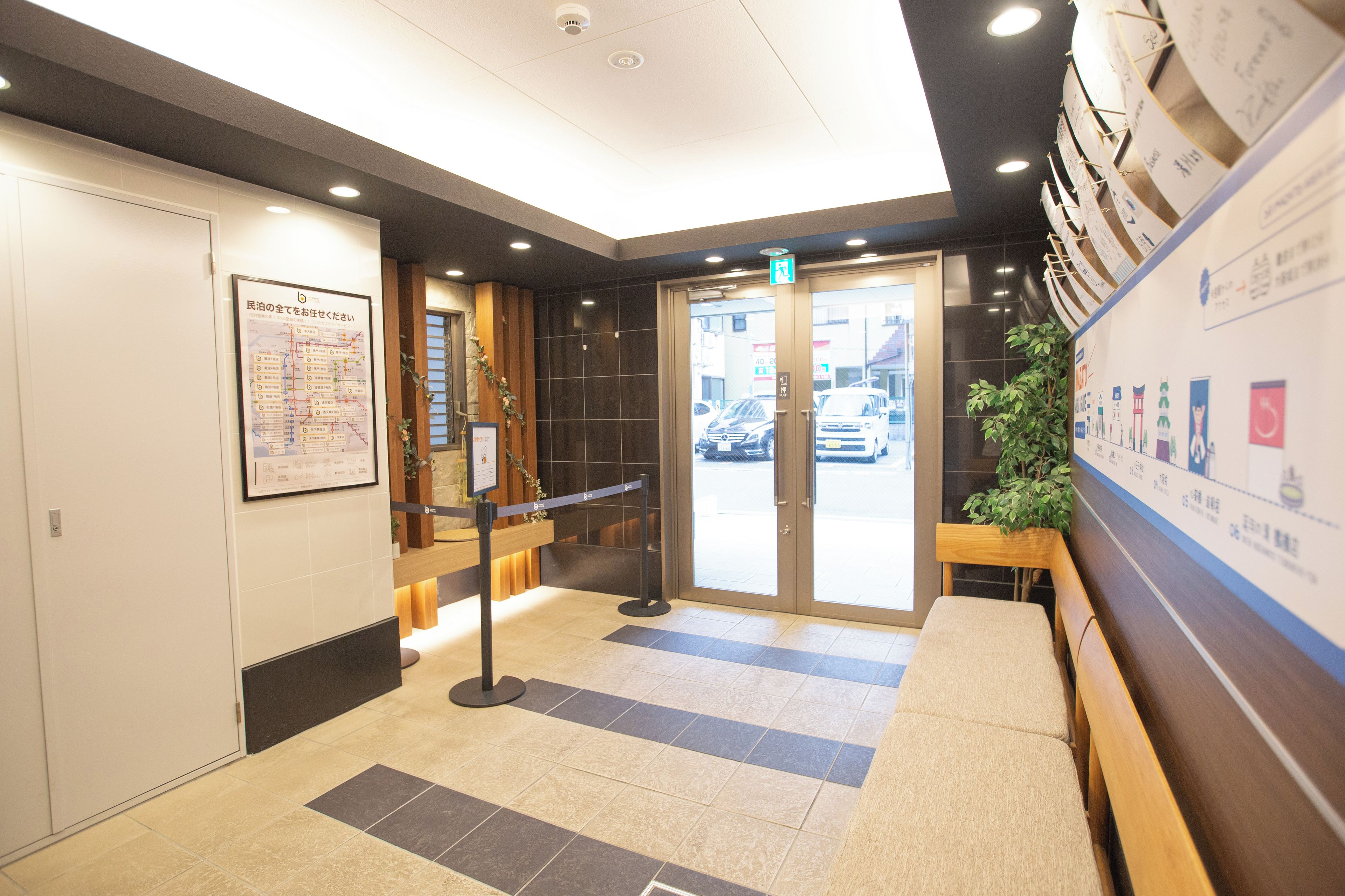 A hotel lobby with a reception desk, a map on the wall, and a plant.