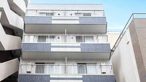 A multi-story building with a modern design, featuring balconies and a ground-level entrance. - b&Imazato (Osaka)