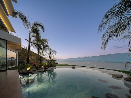 Una piscina al aire libre, sillones reclinables de piscina