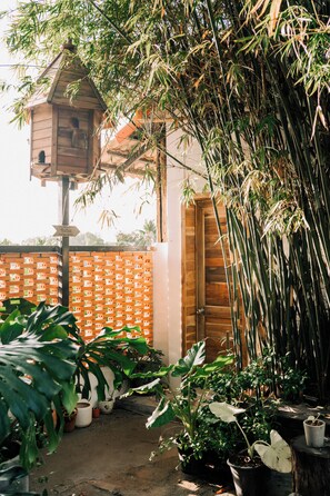 A wooden structure with a birdhouse, surrounded by bamboo and various potted plants. - TINH Retreat Phu Quoc (Phu Quoc)
