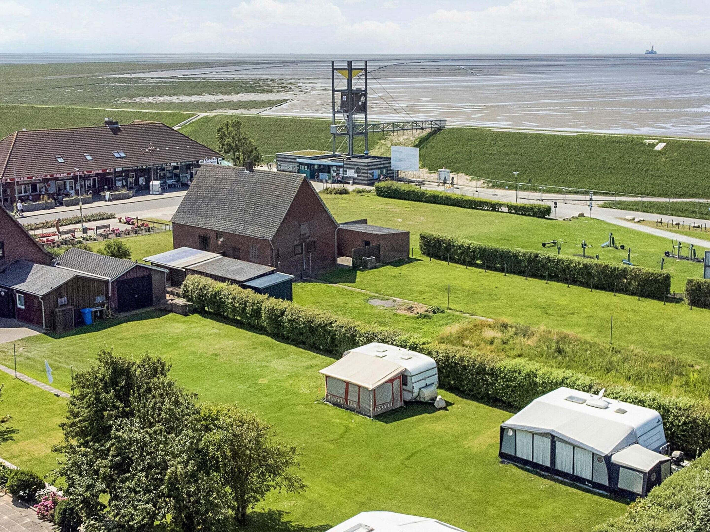 A rural property with a barn, a small house, and a caravan.