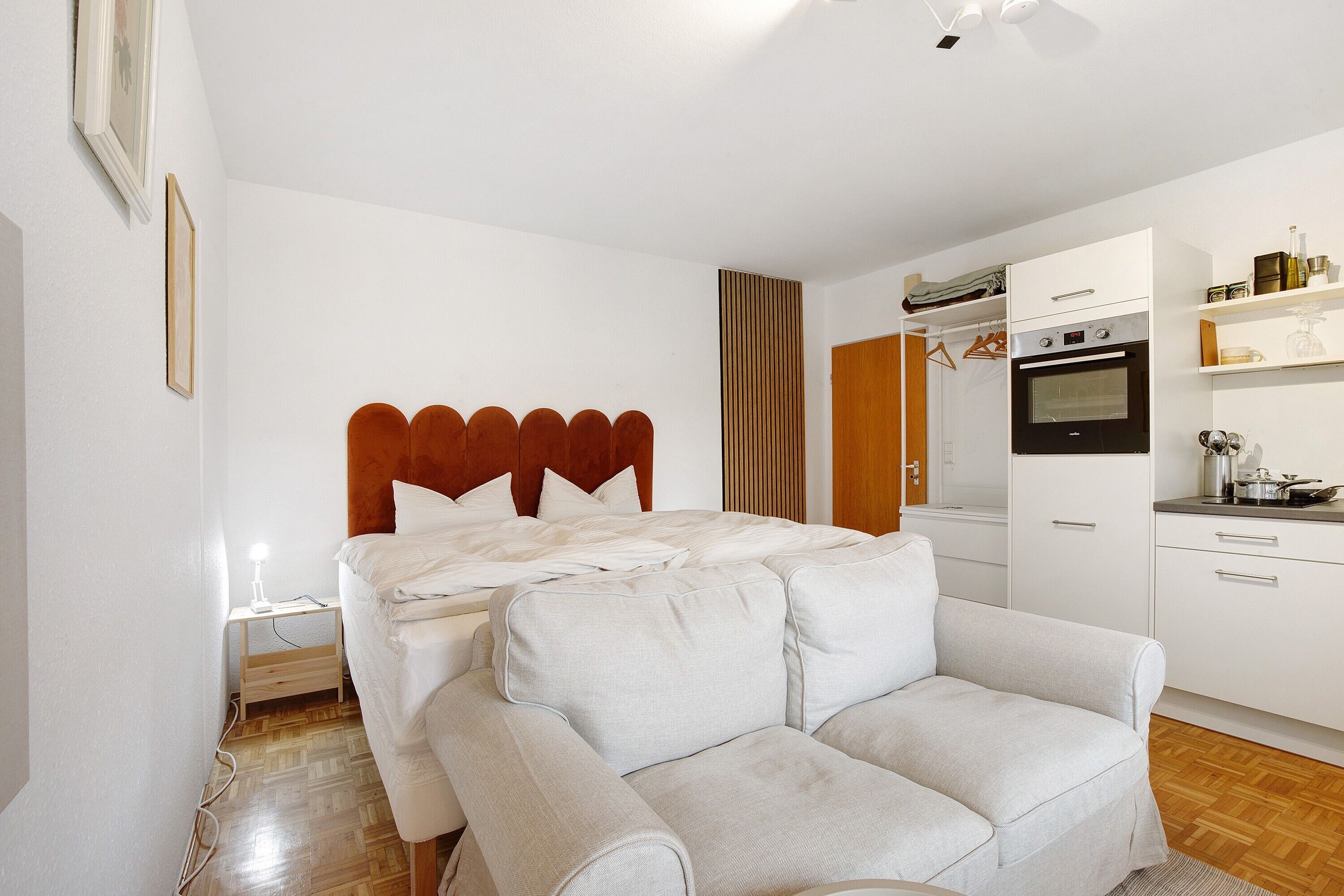 Ein Schlafzimmer mit Bett, Nachttisch und einer Schlafcouch.