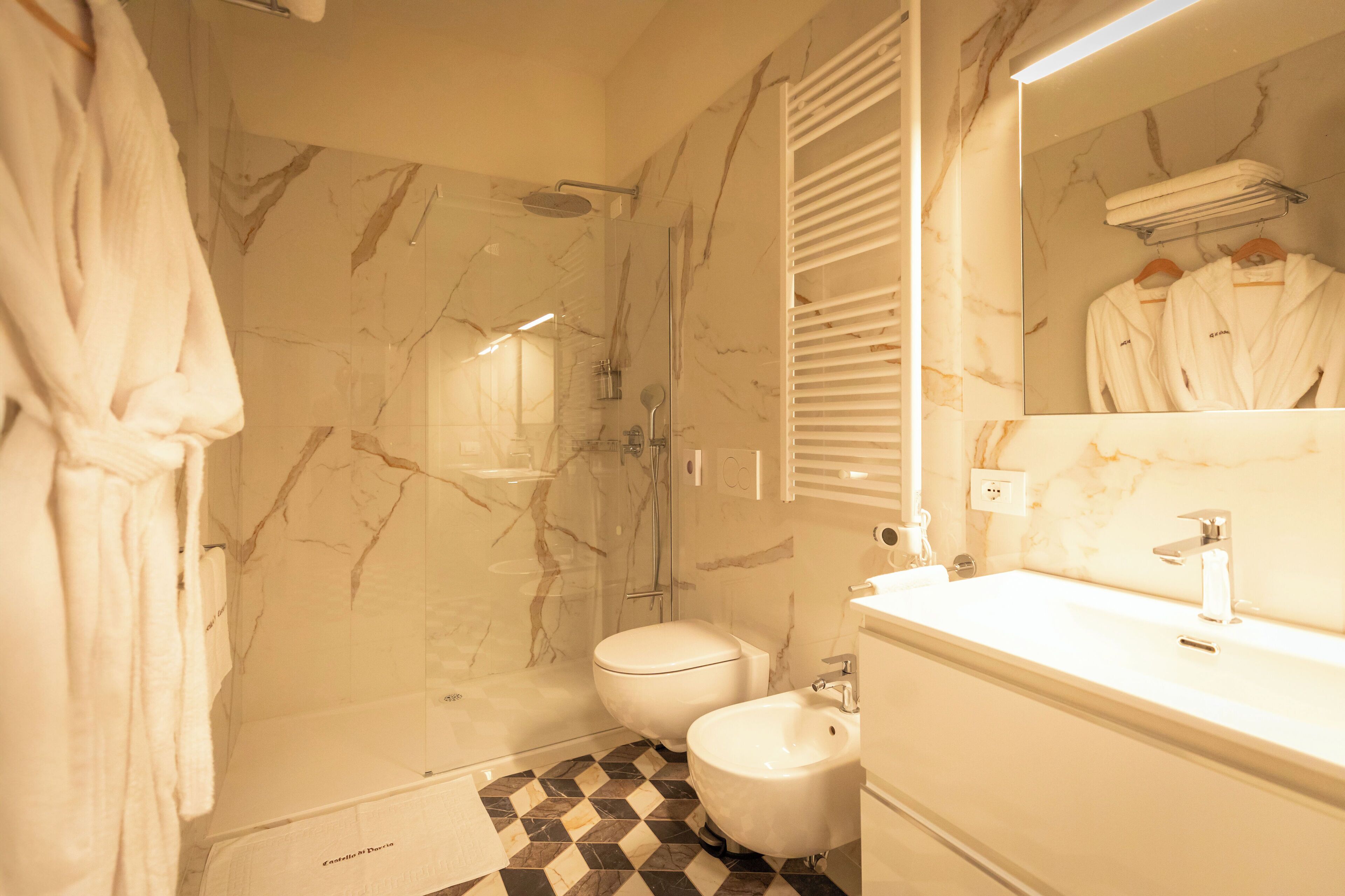 A bathroom with a shower, toilet, and sink.