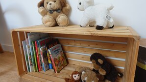 A wooden shelf with books and stuffed animals. - Hotel Bären Guttannen (Guttannen)