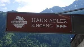 A sign for Hotel Bären indicating direction to Haus Adler Eingang. - Hotel Bären Guttannen (Guttannen)