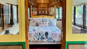 A train car interior with a bed, wooden paneling, and a number 745 on the ceiling. - Yarra Valley Tram Stay (Lilydale)