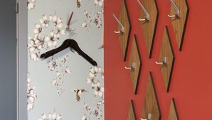 A room with a red wall, a floral wallpaper section, and a table with a red tablecloth.