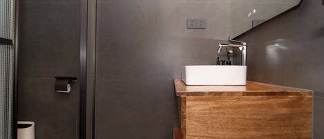 Une salle de bain moderne avec un meuble-lavabo en bois, un lavabo blanc et un miroir.