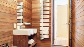 Une salle de bain avec un lambris en bois, un lavabo et un porte-serviettes.