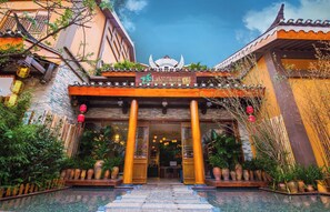 A traditional building with a tiled roof, a signboard, and a welcoming entrance with steps. - 26Life Nationality Inn (Kunming)