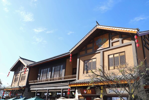 A traditional building with a tiled roof and multiple windows, featuring a signboard with Chinese characters.