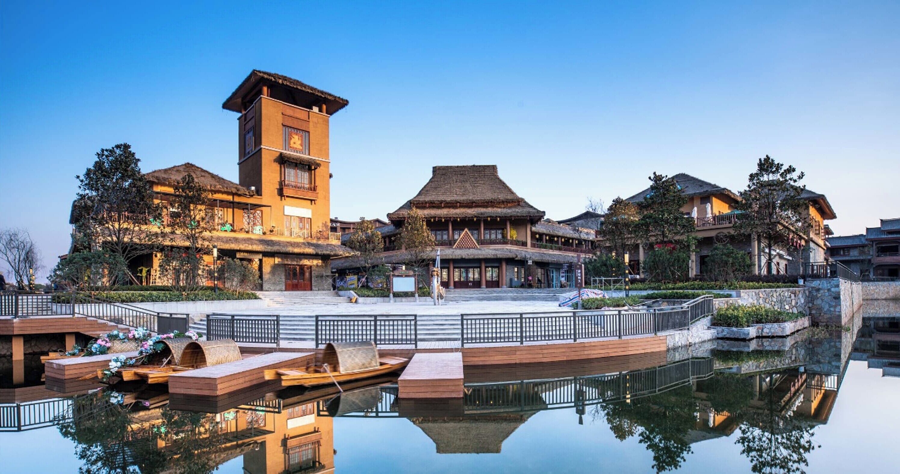 A traditional building with a tower, a courtyard, and a reflection in the water.