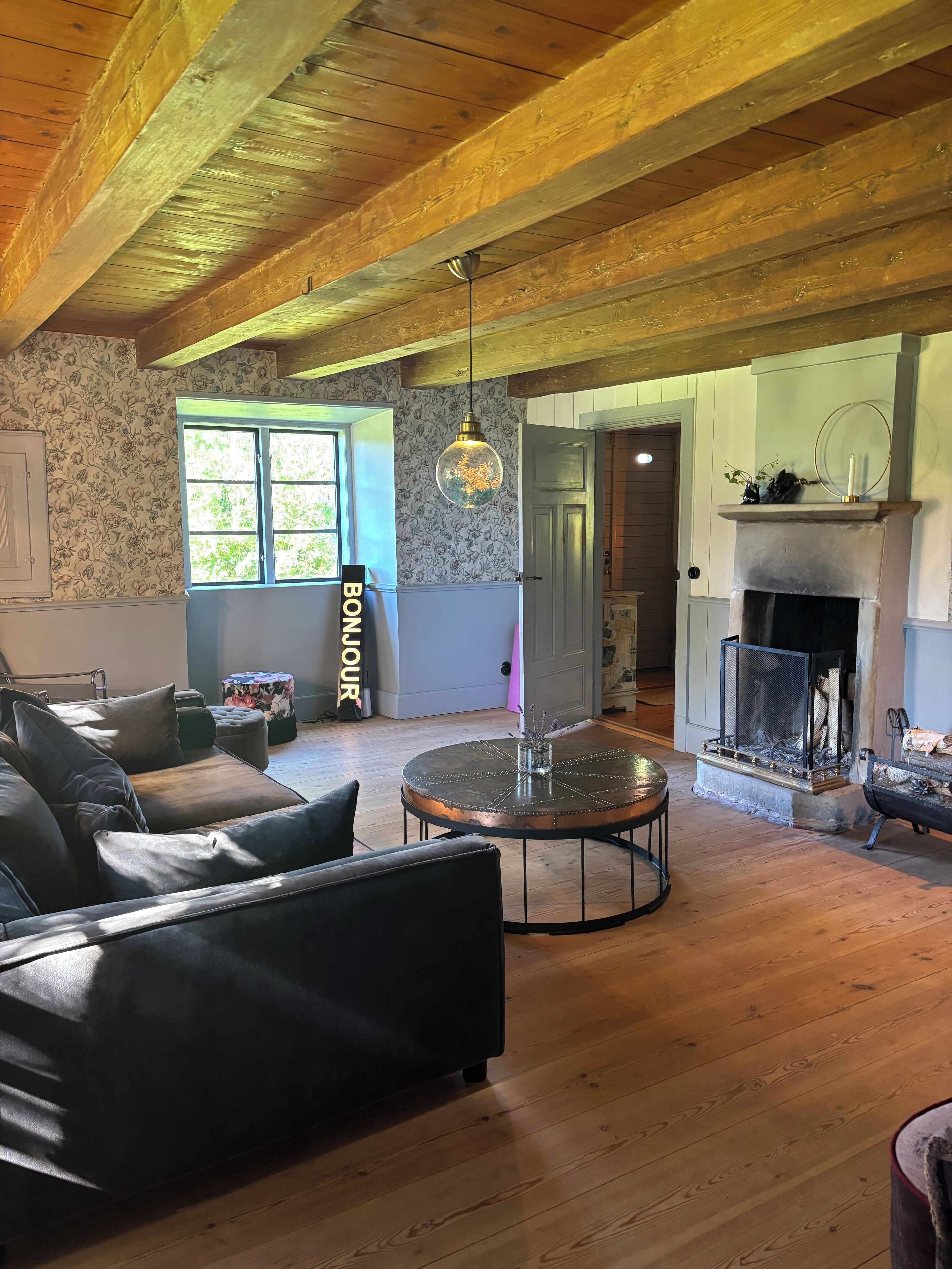 Una sala de estar acogedora con chimenea, una mesa de centro redonda y un sofá de cuero.
