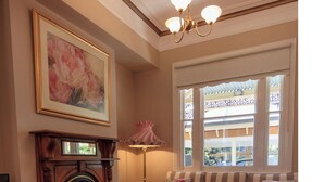 A living room with a fireplace, a sofa, a coffee table, and a chandelier.