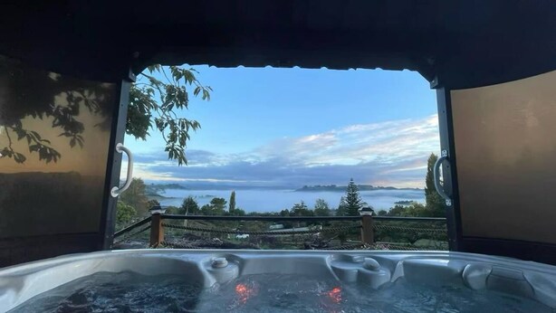 Een hottub met uitzicht op een meer en bergen.