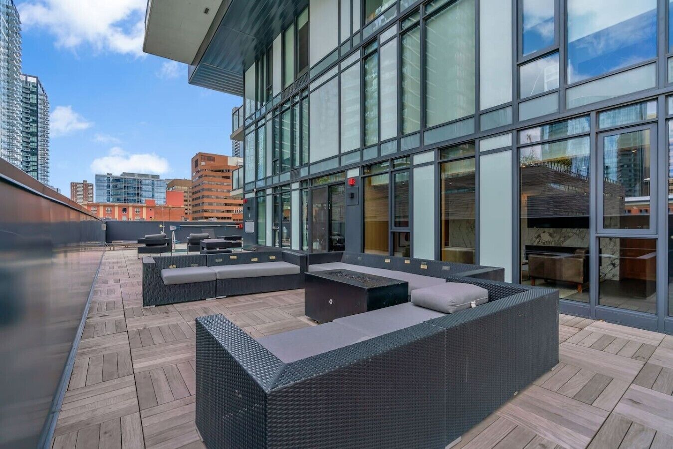 A rooftop terrace with outdoor seating and a view of the cityscape.