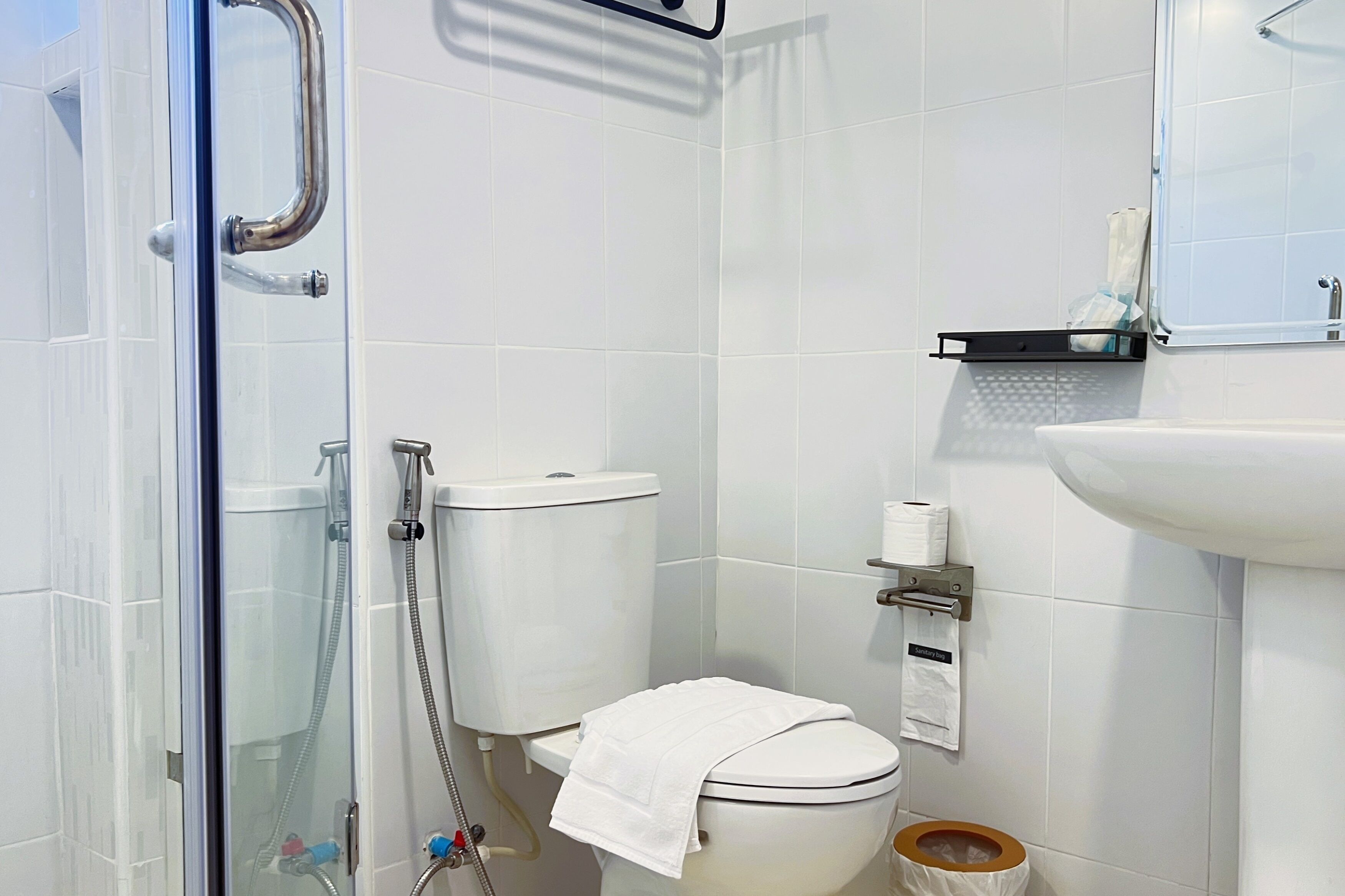 Un baño con cabina de ducha de vidrio, inodoro y lavabo.
