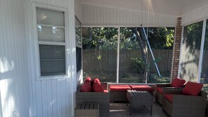 A covered patio with wicker furniture, a ceiling fan, and a view of the backyard. - Classy Comfy 3-bedroom house with AC in Palm Bay (Palm Bay)