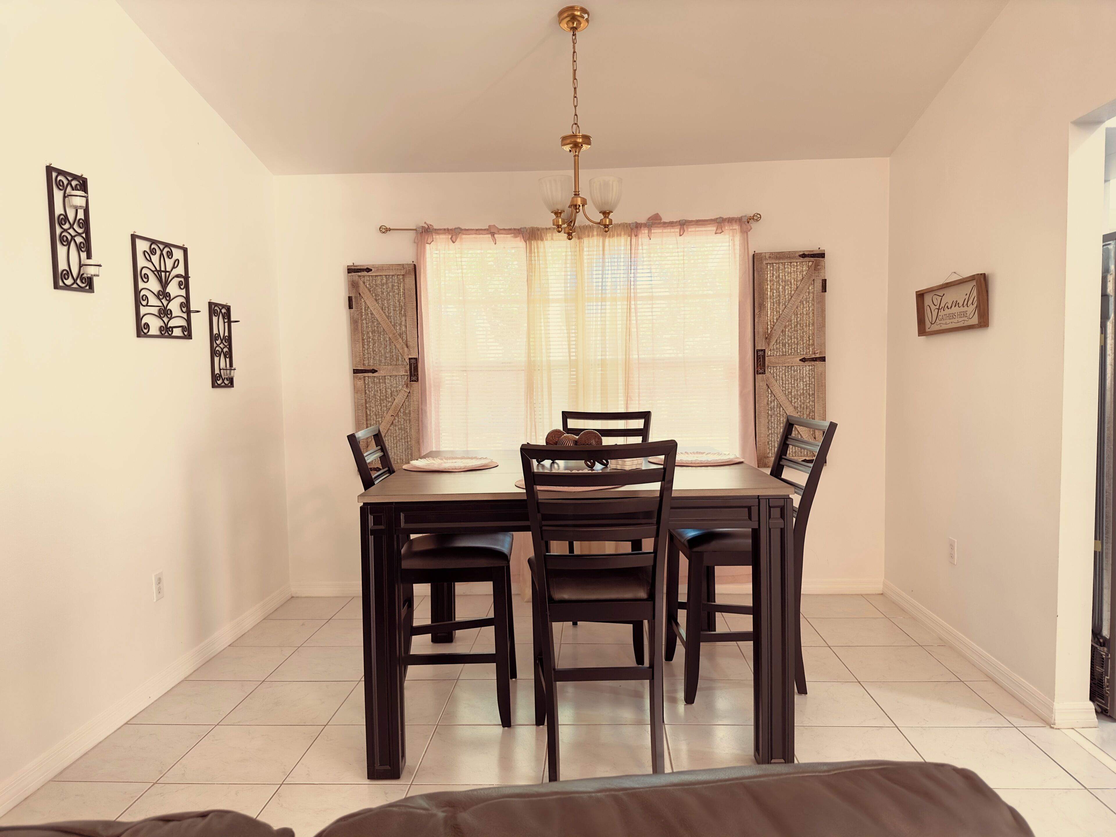 A dining area with a table and chairs, a chandelier, and decorative wall art.