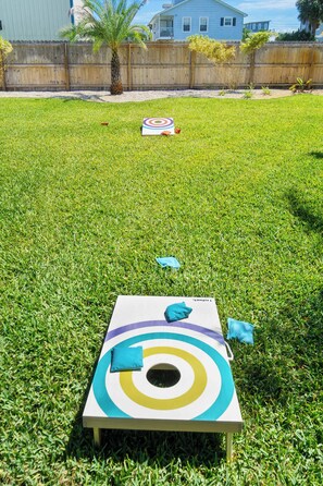 A backyard with a colorful target game set up on the grass. - Fire Pit, Tropical Oasis, Steps to Beach, Patio (St. Augustine)