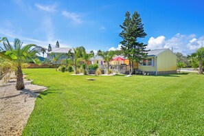 A residential area with a well-maintained lawn, a wooden deck, and a small shed. - Fire Pit, Tropical Oasis, Steps to Beach, Patio (St. Augustine)