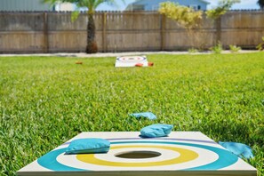 A target board on a grassy lawn with a wooden fence in the background.