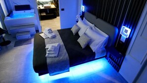 Una habitación de hotel moderna con una cama, un escritorio pequeño con una computadora y una silla de masaje.