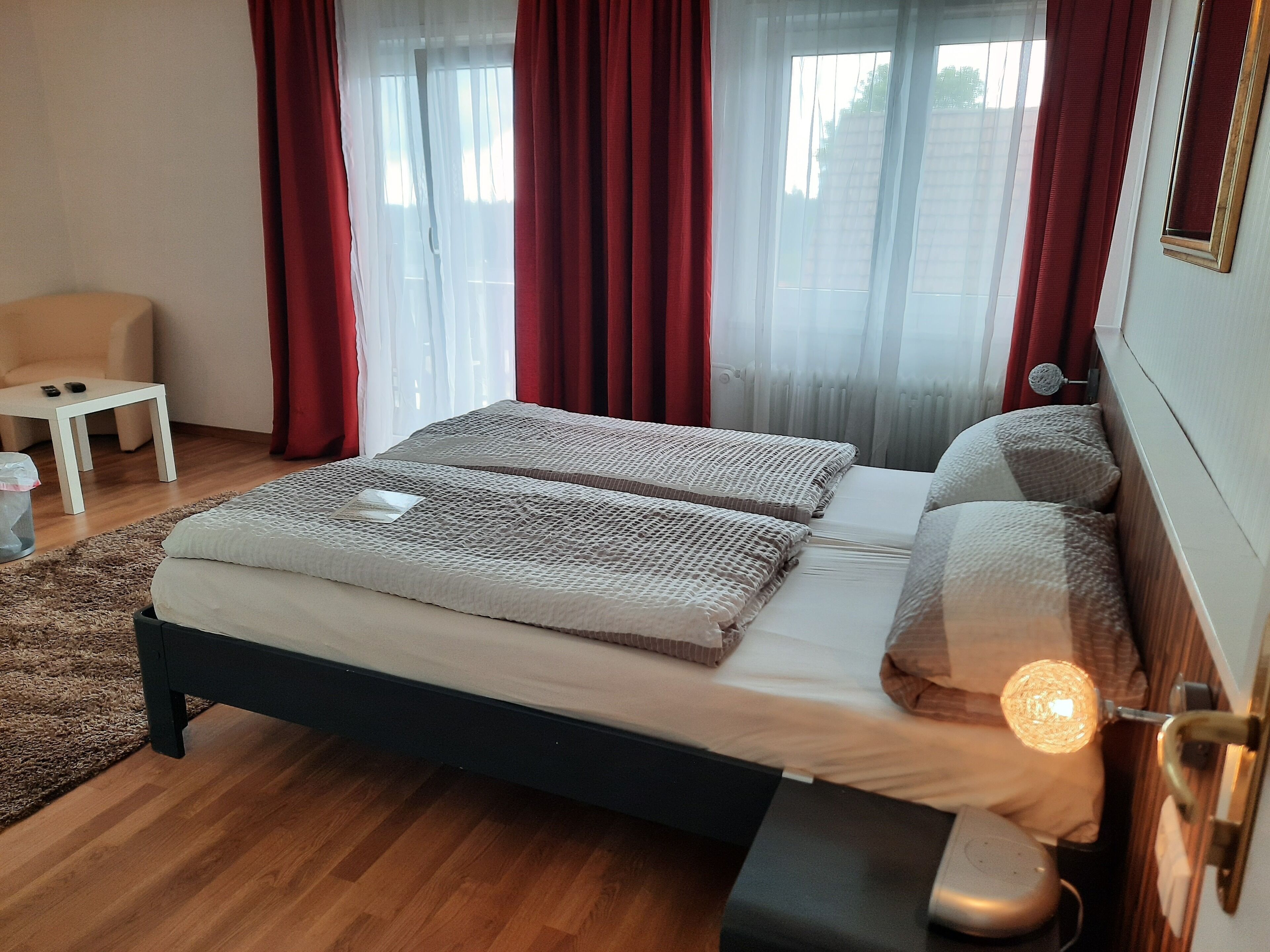 A bedroom with a bed, bedside table, and a lamp.