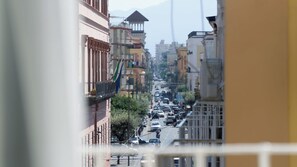 Vista de la calle con edificios, coches y cielo despejado.