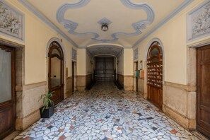 A hallway with a mosaic floor, wooden doors, and decorative ceiling. - Giolitti San Carlo Stay by Wonderful Italy (Turin)