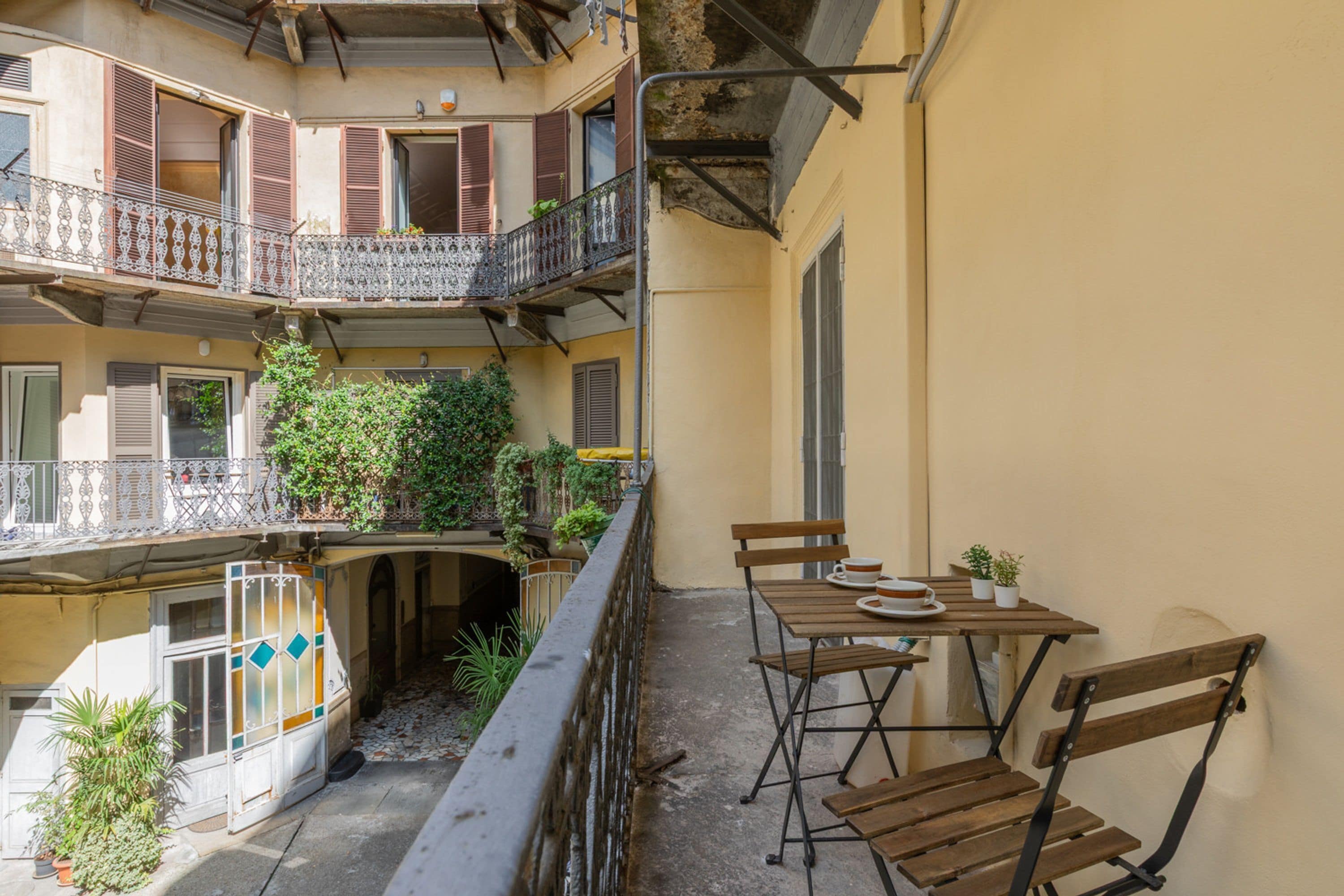 A multi-level apartment with balconies, outdoor seating, and potted plants.