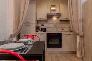 A compact kitchen with a stove, oven, and modern cabinetry. - Giolitti San Carlo Stay by Wonderful Italy (Turin)