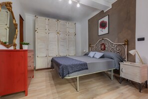 A bedroom with a bed, a dresser, a nightstand, a mirror, and a wardrobe. - Giolitti San Carlo Stay by Wonderful Italy (Turin)