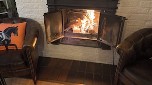 Une cheminée à foyer ouvert, laissant apparaître les flammes.