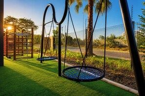 A playground with swings and a climbing structure.