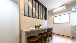 Une cuisine moderne dotée d’un îlot central, de tabourets de bar et d’une grande fenêtre.