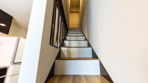 Un escalier moderne avec des marches en bois et une rampe en m étal, menant à un palier.