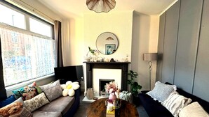 A living room with a sofa, a coffee table, a fireplace, and a television. - Cosy Stay in Coventry CV5 | King Bed & Twin Room | Free Parking | Sleeps 4 (Coventry)