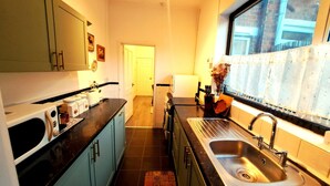 A kitchen with a sink, countertop, and cabinets. - Cosy Stay in Coventry CV5 | King Bed & Twin Room | Free Parking | Sleeps 4 (Coventry)