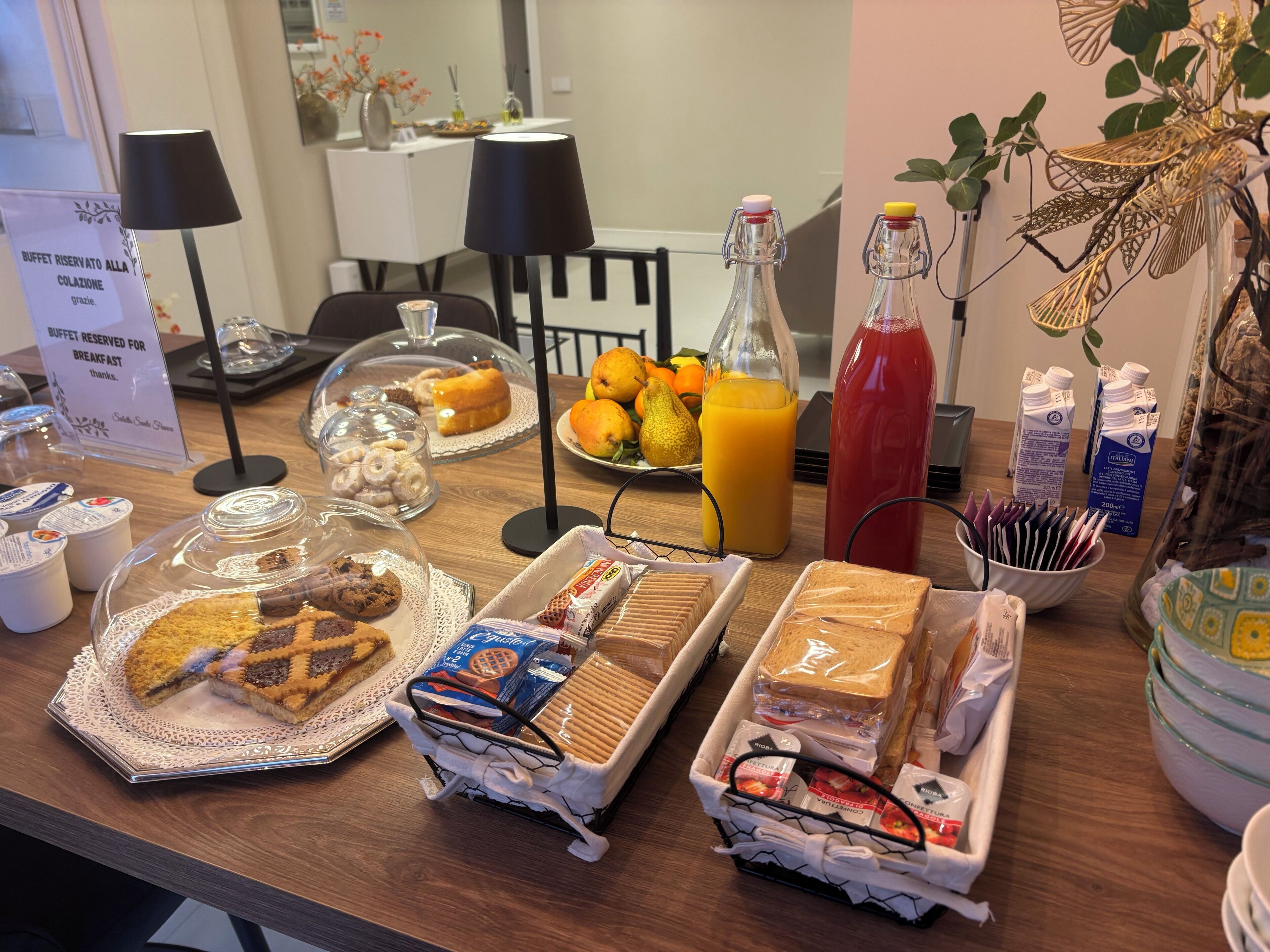 A breakfast buffet with various food items, including pastries, bread, and juice.