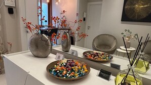 Une cuisine moderne avec un plan de travail blanc, des vases décoratifs et un grand miroir.