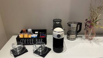 Una barra de café con una cafetera, una jarra de café y una caja con la etiqueta 'COFFEE BAR'.