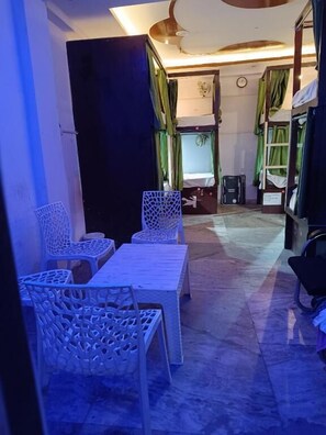 Une pièce avec des lits superposés, une table et des chaises.