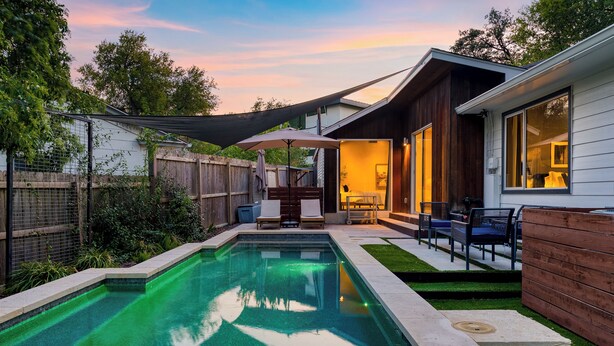 A backyard with a swimming pool, a wooden deck, and a covered seating area. - 4BDR House w/ Pool & Guest House in Central Austin (Austin)
