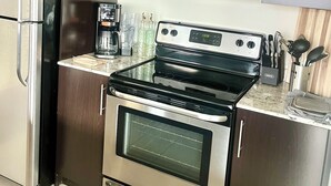 A kitchen with stainless steel appliances, including a refrigerator, microwave, and oven. - Beautiful Two-Bedroom Escape Ocean & City Views from Every Room (San Diego)
